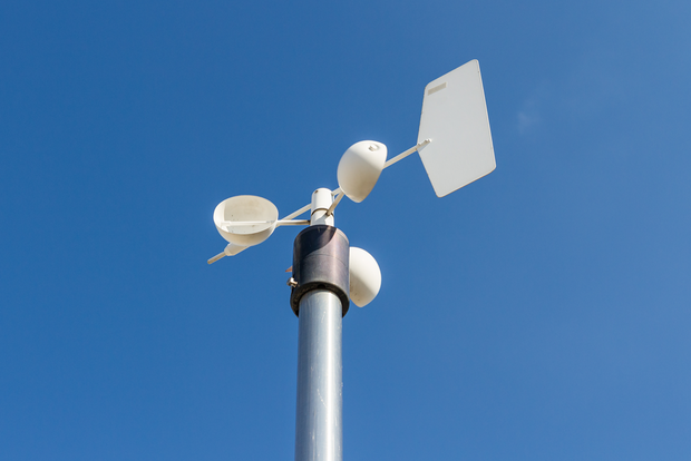Close up of an anemometer on top of the pole against the clear blue sky
